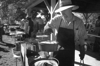 
A cook moves a dutch oven around on his table at a cooking demonstration in Rathdrum in 2003. 
 (File photos / The Spokesman-Review)