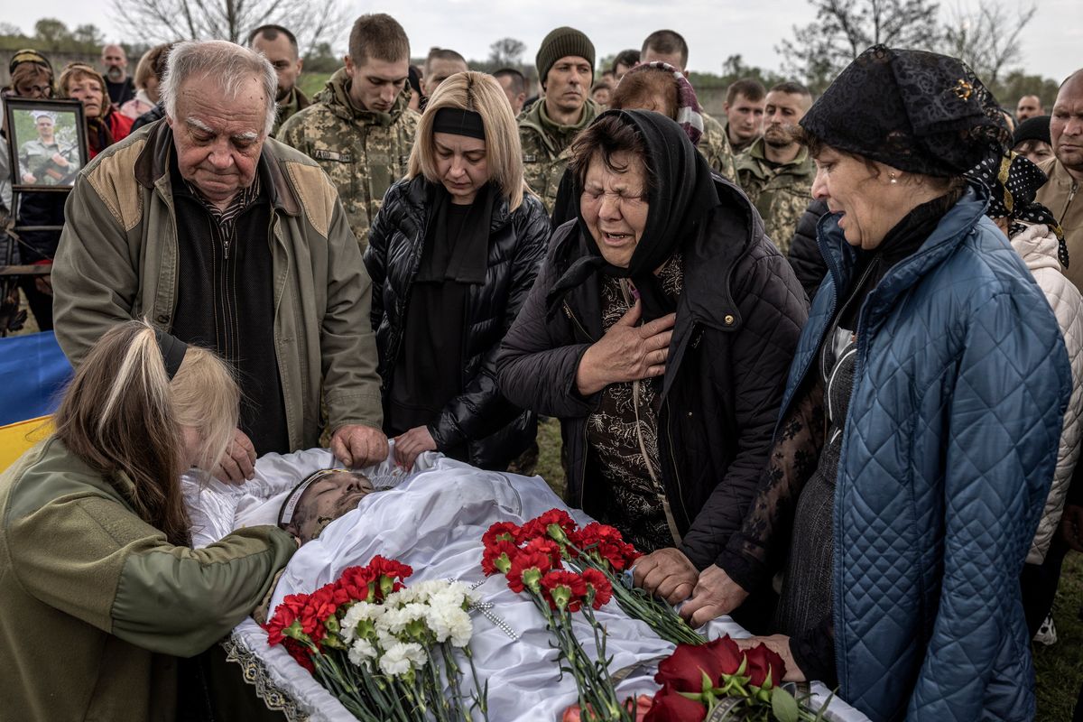 Volodymyr Dykiy, left, and Lidiia Duka, center, grieve over the body of their son, Ukrainian service member Oleksandr Dykiy, 41, who was killed last week near Bakhmut, during his funeral in his hometown of Mykhaylivsʹka Tserkva, in the Kyiv region of Ukraine on April 22, 2023. (Finbarr O