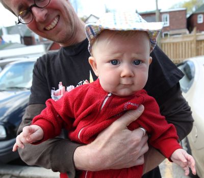 David Stocker holds his 4-month-old child, Storm, in Toronto. (Associated Press)