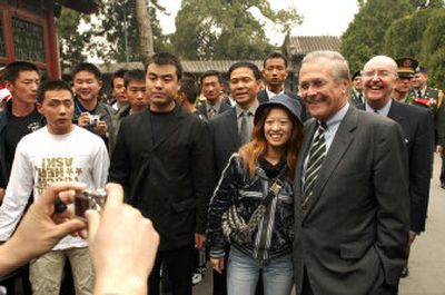 
U.S. Secretary of State Donald Rumsfeld poses for a photo with Chinese tourists as Clark Randt, U.S. ambassador to China, smiles behind him during a visit to the Summer Palace in Beijing Thursday. 
 (Associated Press / The Spokesman-Review)