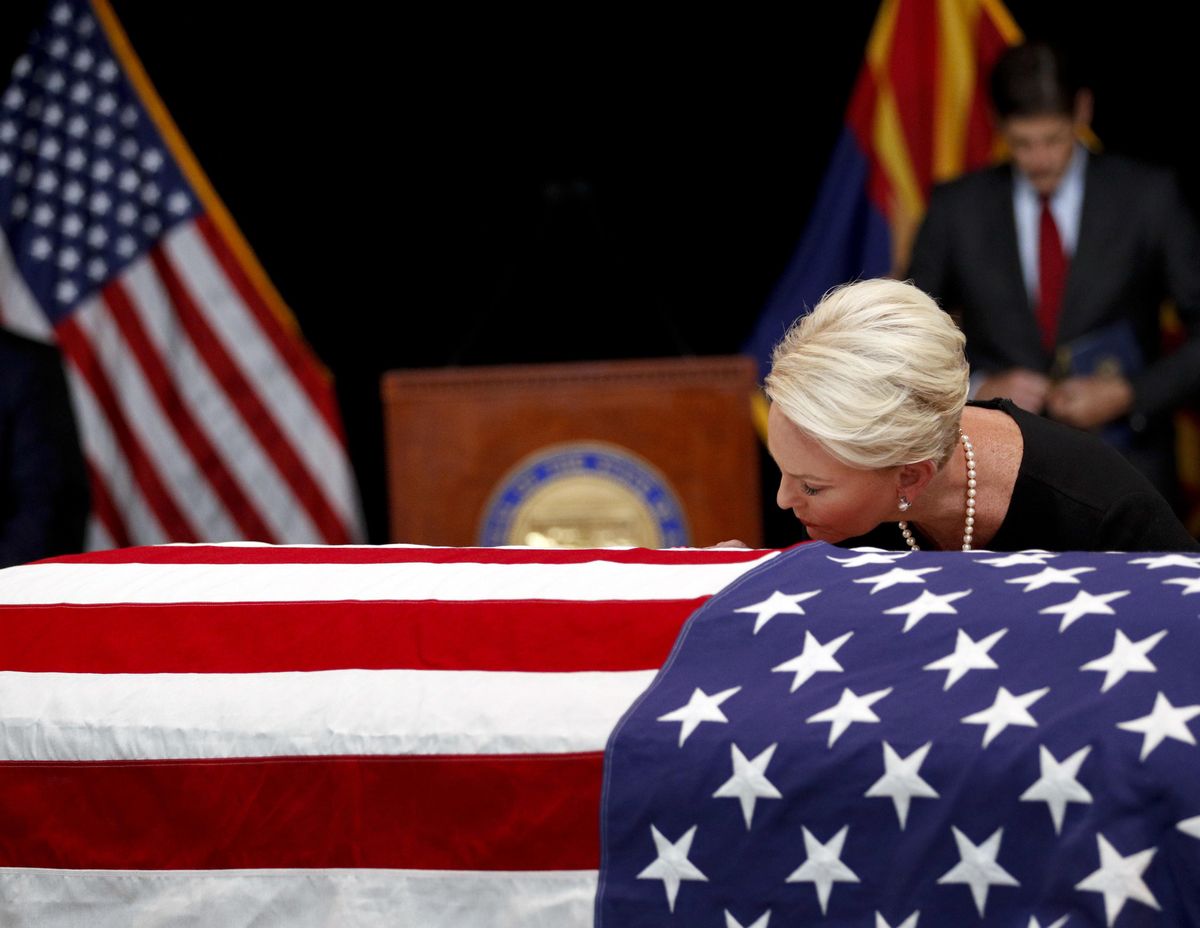 Cindy McCain, wife of, Sen. John McCain, R-Ariz. touches the casket during a memorial service at the Arizona Capitol on Wednesday, Aug. 29, 2018, in Phoenix. (Jae C. Hong / Associated Press)