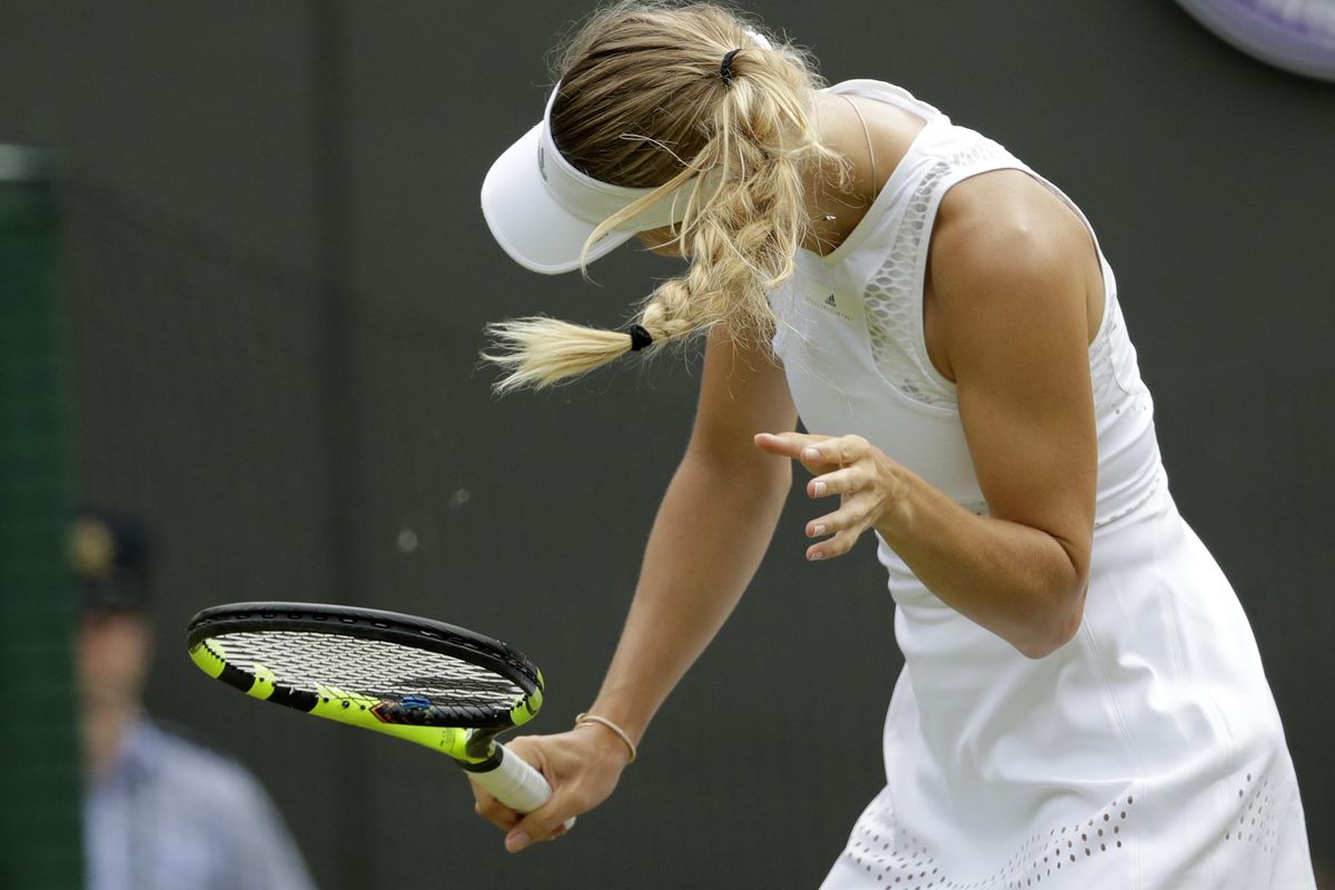 Caroline Wozniacki of Denmark shakes her head to avoid the flying insects on court during the women’s singles match against Ekaterina Makarova of Russia on the third day at the Wimbledon Tennis Championships in London, Wednesday July 4, 2018. (Ben Curtis / Associated Press)