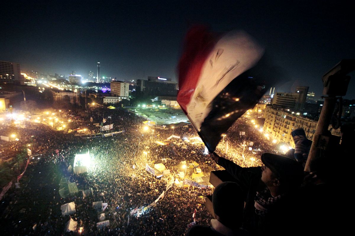 In this Jan. 25, 2012 file photo, people wave flags in Tahrir Square to mark the first anniversary of the popular uprising that led to the quick ouster of autocrat President Hosni Mubarak, in Cairo, Egypt. A decade later, thousands are estimated to have fled abroad to escape a state, headed by President Abdel Fattah el-Sissi, that is even more oppressive.  (Amr Nabil)