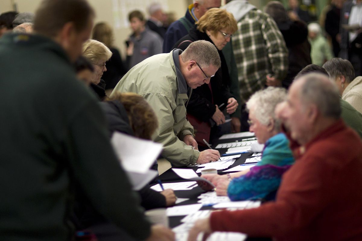 In this Jan. 3, 2012 file photo, voters sign in on caucus night at Point of Grace Church in Waukee, Iowa. (Evan Vucci / AP)