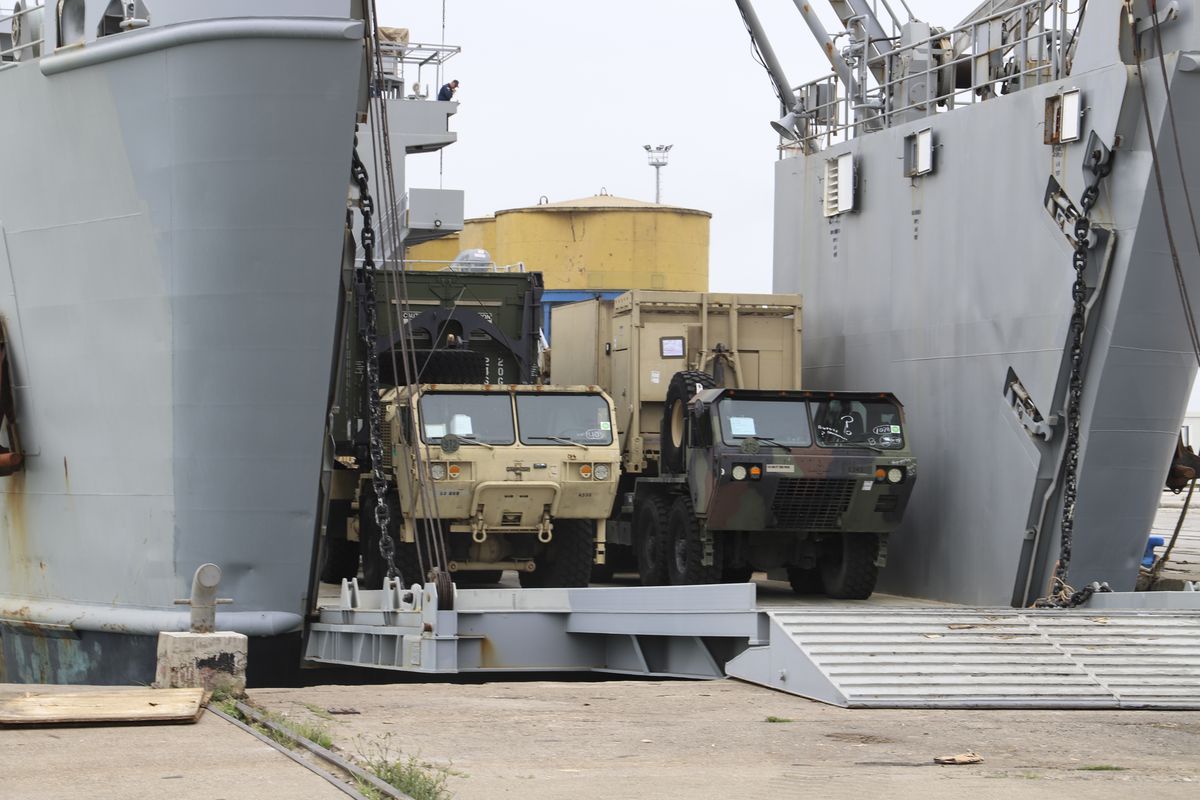 U.S. army vehicles disembark from a vessel at Albania