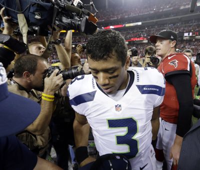 Down and out: Seattle quarterback Russell Wilson leaves the field Sunday after shaking hands with Atlanta quarterback Matt Ryan, whose Falcons eliminated the Seahawks from the NFC playoffs with a dramatic 30-28 victory. The Wilson-led Seahawks overcame a 20-0 halftime deficit to take a 28-27 lead with 31 seconds left, but Atlanta prevailed on Matt Bryant’s 49-yard field goal with 8 seconds remaining. Wilson threw two touchdown passes and ran for another as the Seahawks finished the season 12-6. Atlanta advanced to next Sunday’s NFC championship game against San Francisco. See Sports, Page B1. (Associated Press)