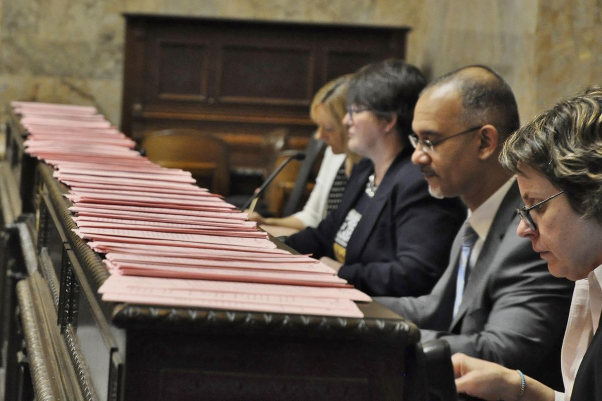 OLYMPIA – Amendments line the bar in front of the Deputy Clerk Nona Snell, Chief Clerk Bernard Dean and other members of the House administration before debate begins on the 2017-19 operating budget. (Jim Camden / The Spokesman-Review)
