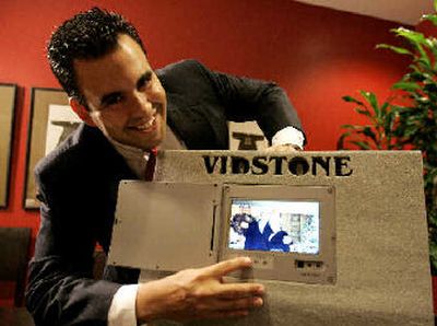 
Sergio Aguirre, founder of Vidstone LLC, poses with his product featuring a solar-powered video panel embedded in a tombstone in his Miami office on Thursday. 
 (Associated Press / The Spokesman-Review)