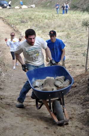 Project draws hundreds of volunteers: Matt Meyer, an engineering student at Gonzaga University, puts his muscle into moving rock during a community work project at the Dishman Hills Natural Area on Saturday. More than 330 people volunteered to help. The event was sponsored by REI and several outdoor groups. (Rich Landers)