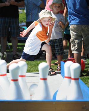Samuel Randall, 6, watches after he throws a plastic bowling ball at oversize pins at a game booth at Liberty Lake Days on Saturday at Pavillion Park.