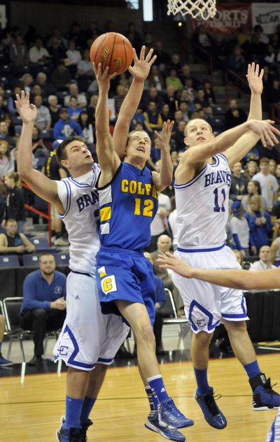 Colfax's Brady Ellis (12) knifes between LaConner's Tyler Howlett, left, and Sean Hulbert, right, on his way to the basket in the second half of the Colfax-LaConner matchup, Thursday, Feb. 28, 2013, at the State B Hardwood Classic at the Spokane Arena. (Jesse Tinsley / The Spokesman-Review)