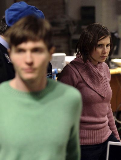 Amanda Knox walks behind Raffaele Sollecito as she arrives after a break to attend a hearing in her appeals trial, at the courthouse in Perugia, Italy, on Saturday.  (Associated Press)