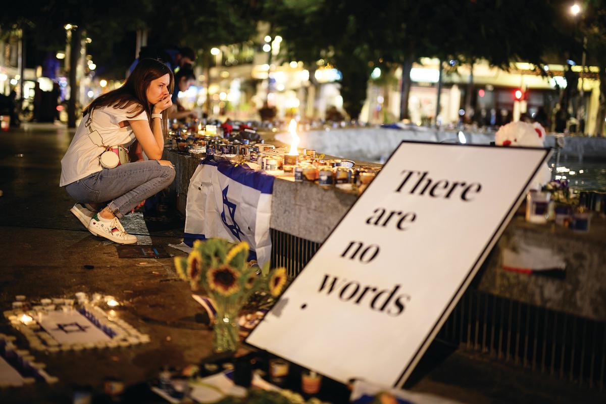 A sign at a candle vigil for those killed or taken hostage by Hamas on Friday in Tel Aviv.  (Leon Neal)
