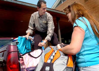 
Tomlinson Black Realtor Don Campbell and office manager Cindy Calvert unload backpacks and tote bags at Spokane Valley Partners Community Center Thursday. The company donated 150 bags to Spokane Valley Partners' program that helps low-income families in the community prepare for the school year with clothing and school supplies. 
 (Joe Barrentine / The Spokesman-Review)