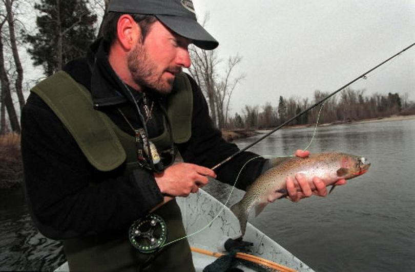 
 Drew Miller of Missoula pauses with a cutthroat trout caught while dry fly fishing on the Bitterroot River.  (Rich Landers)