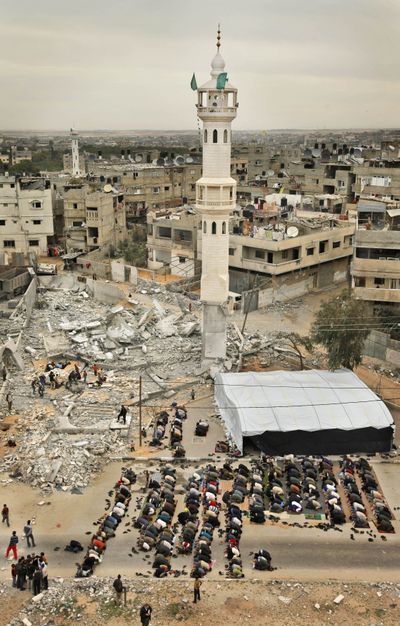 Palestinians take part in  Muslim Friday prayers on the street outside a destroyed mosque, where only the minaret still stands, in Beit Lahiya, Gaza Strip, on Friday.  (Associated Press / The Spokesman-Review)