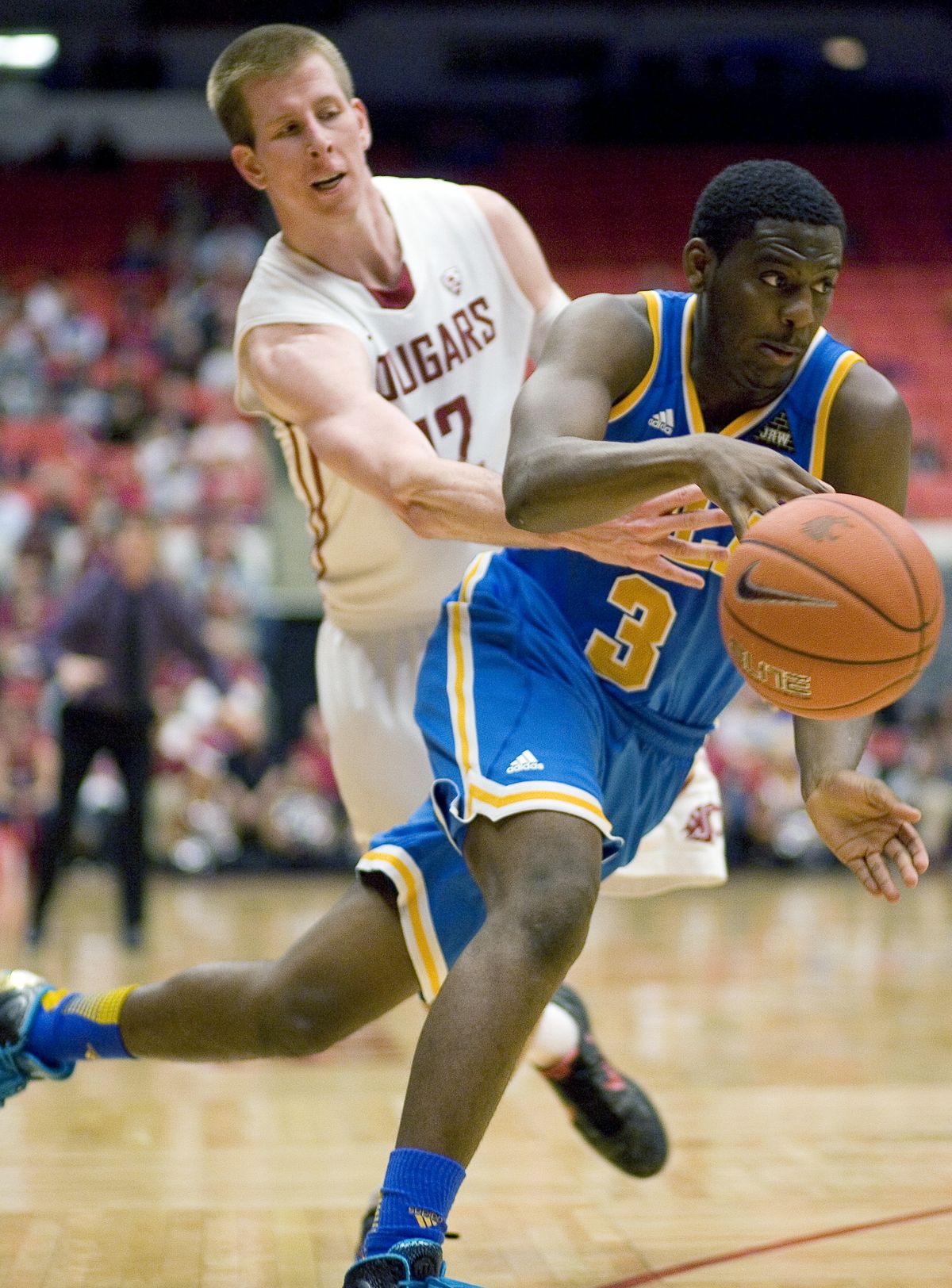 Brock Motum tips the ball away from UCLA’s Jordan Adams. (Associated Press)