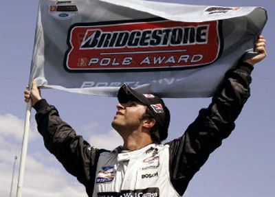 
Brazilian Champ car driver Bruno Junqueira holds up the pole award flag after the final day of qualifying in the Portland Grand Prix.
 (Associated Press / The Spokesman-Review)