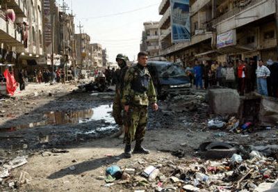 
Iraqi army soldiers guard the site of a car bomb explosion in Baghdad, Iraq, on Tuesday. Four explosions rocked the capital Tuesday morning, killing dozens of people, police said. 
 (Associated Press / The Spokesman-Review)