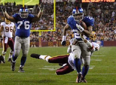 
New York running back Tiki Barber drags Washington's Sean Taylor into end zone.
 (Associated Press / The Spokesman-Review)
