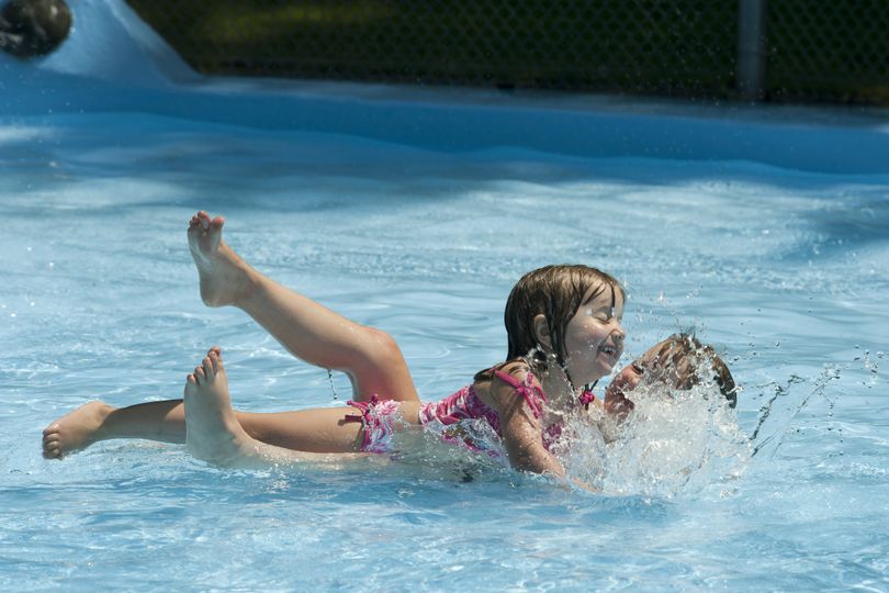 Daisy Hanson and Kelsie Brulotte splash around in the Millwood wading pool Thursday. Community donations made it possible for the pool to reopen after being closed last year. (Dan Pelle)