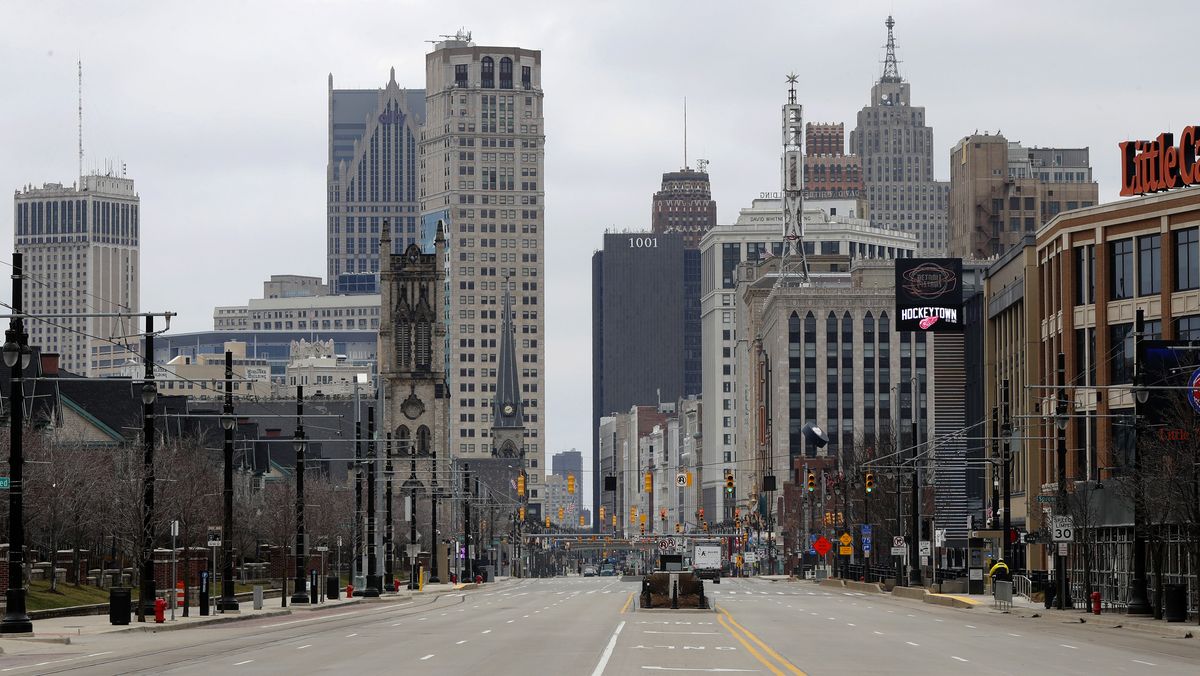 In this March 24, 2020 file photo, Woodward Avenue is shown nearly empty in Detroit. Before the coronavirus showed up, downtown Detroit was returning to its roots as a vibrant city center, motoring away from its past as the model of urban ruin. Now, with the coronavirus forcing many office workers to their homes in the suburbs, those who remain wonder if revitalization will ever return.  (Paul Sancya)