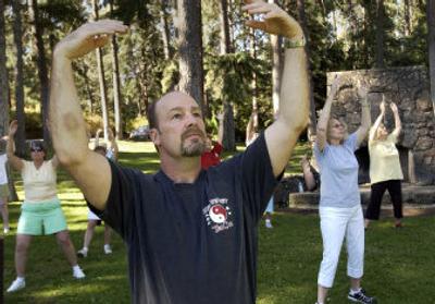 
Bryan Knack leads his qigong class through fluid arm movements on Saturday morning at the west end of the Manito Park duck pond. 
 (Dan Pelle / The Spokesman-Review)
