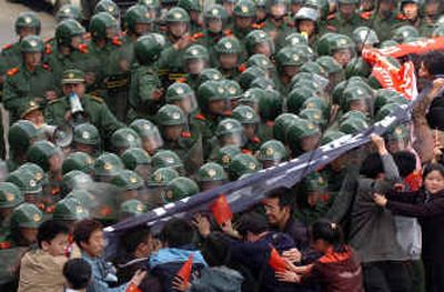 
Chinese paramilitary soldiers stand guard as anti-Japanese protesters demonstrate outside of the Japanese consulate in the northeastern Chinese city of Shenyang on Sunday.  
 (Associated Press / The Spokesman-Review)