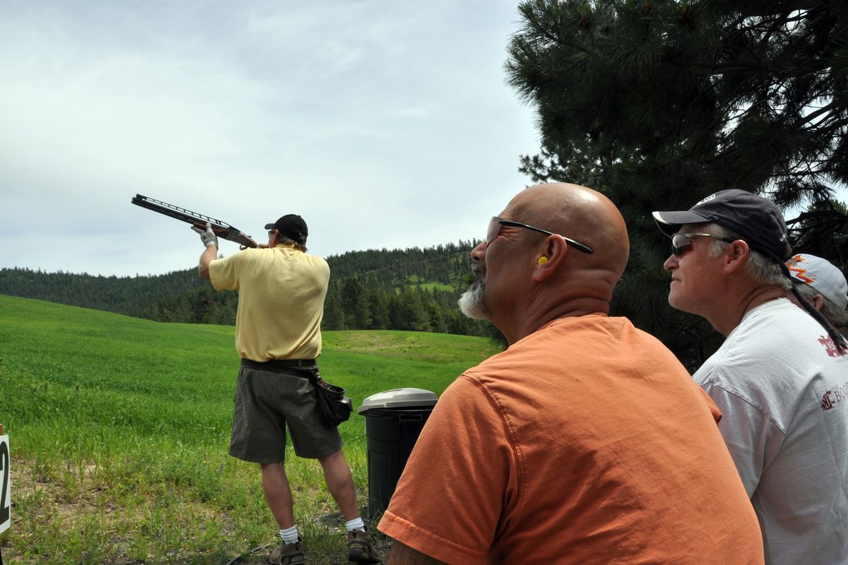 Double Barrel Ranch owner Ron Olmstead, bottom left, watches with a squad of shooters as Bob Dunn shoots a station on the sporting clays range Olmstead designed off Harvard Road just south of Mica Peak. (Rich Landers)
