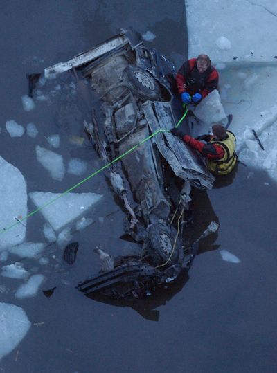 ORG XMIT: IDBOI101 Diver attach lines to a vehicle in the Mores Creek in Boise, Idaho, Thursday Feb. 19, 2009. A woman on her way to Boise was killed when the pickup went over a 350-foot embankment near the High Bridge and into the creek.  It is unknown if other people were in the car.  (AP Photo/KATHERINE JONES/ Idaho Statesman)  ** MANDATORY CREDIT ** (Katherine Jones / The Spokesman-Review)