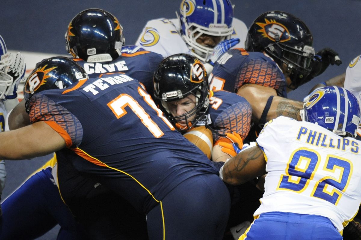 Spokane Shock quarterback Kyle Rowley, center, is sandwiched Saturday as he scores on a first-half keeper against the Tampa Bay Storm. (Jesse Tinsley)