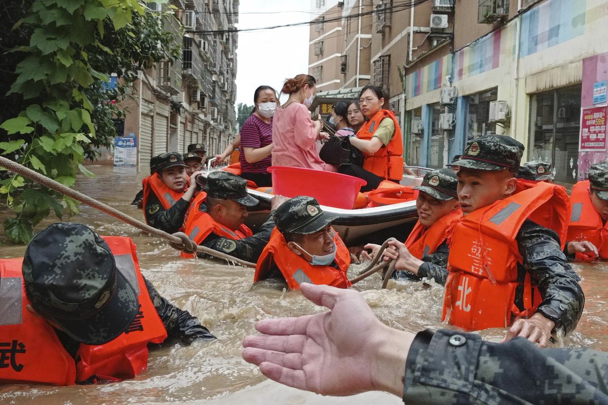 FILE - In this Thursday, Aug. 12, 2021 file photo, paramilitary police work to evacuate people trapped in a flooded area in Suizhou in central China