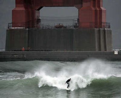 
A surfer rides a wave churned by a winter storm under the  Golden Gate Bridge on Friday. Photos by Associated Press
 (Photos by Associated Press / The Spokesman-Review)