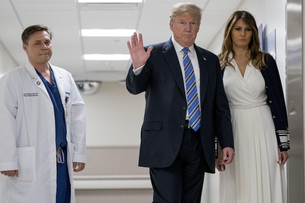 President Donald Trump, center, accompanied by first lady Melania Trump, right, and Dr. Igor Nichiporenko, left, waves to reporters while visiting with medical staff at Broward Health North in Pompano Beach, Fla., Friday, Feb. 16, 2018, following Wednesday’s shooting at Marjory Stoneman Douglas High School, in Parkland, Fla. (Andrew Harnik / Associated Press)