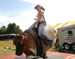 Rebecca Daoust of Tilton, N.H., rides a mechanical bull during the first annual Redneck Olympics in Hebron on Saturday. (Jose Journal)