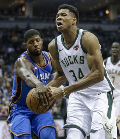 Oklahoma City Thunder’s Paul George knocks the ball out of the hands of the driving Milwaukee Bucks’ Giannis Antetokounmpo during the second half of an NBA basketball game Tuesday, Oct. 31, 2017, in Milwaukee. (Tom Lynn / Associated Press)