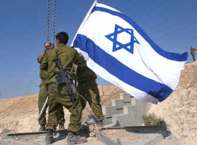 
Israeli soldiers remove an Israeli flag as they dismantle an army checkpoint Wednesday at the entrance of Jericho.
 (Associated Press / The Spokesman-Review)