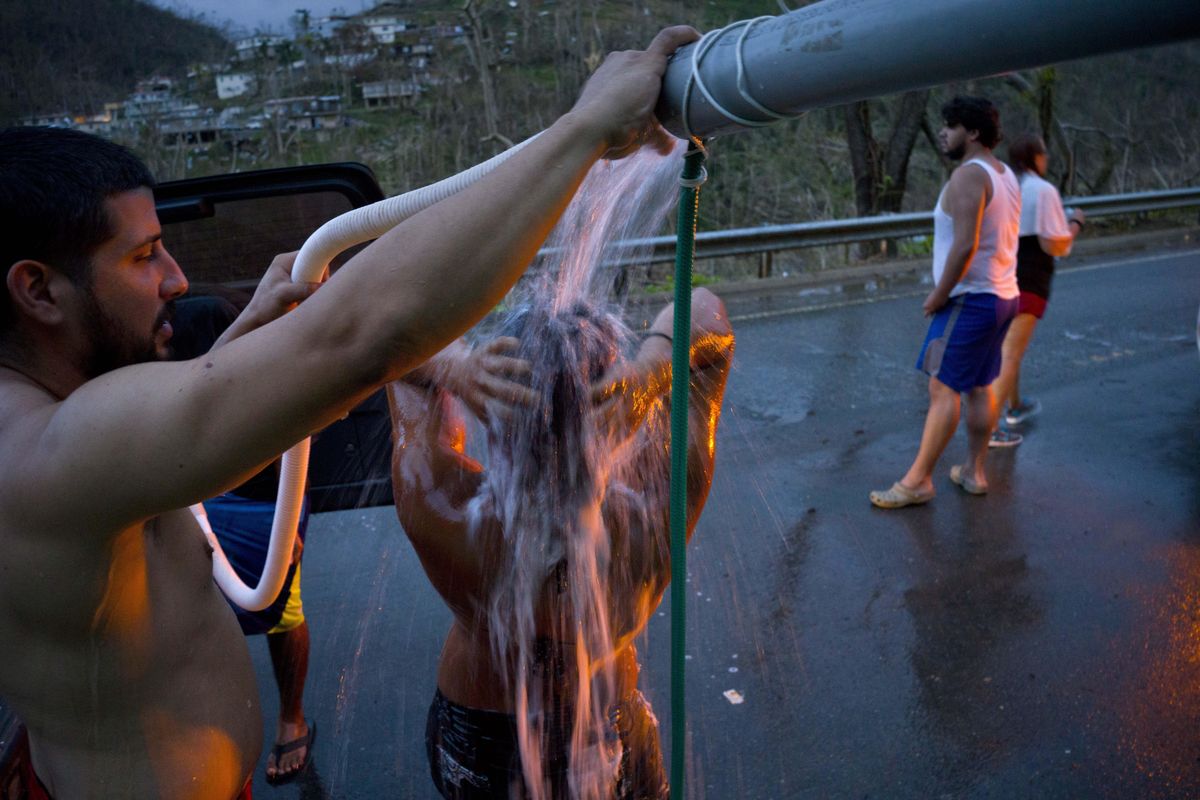 People affected by Hurricane Maria bathe in water piped from a creek in the mountains, Sept. 28, 2017, in Naranjito, Puerto Rico. (Ramon Espinosa / Associated Press)