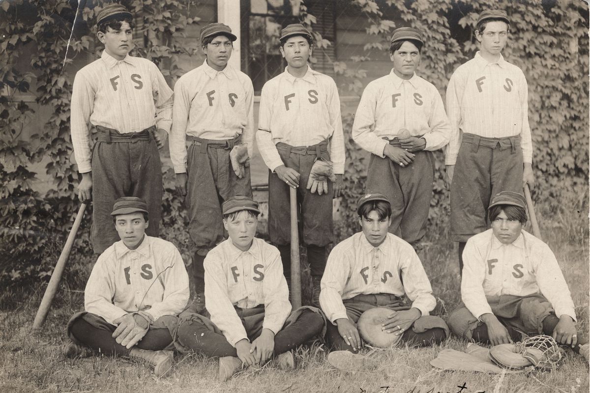 Students on the Fort Spokane Boarding School baseball team stand for a picture. Standing, left to right: Eli Raymond, Marshall(?), Johnny Peone, Gilbert Desantel, George Dupree; Seated: Dan Stranger or Stanger, Bill Desautel, Albert Garry, Philip Pecorris.  (COURTESY OF NATIONAL PARK SERVICE)