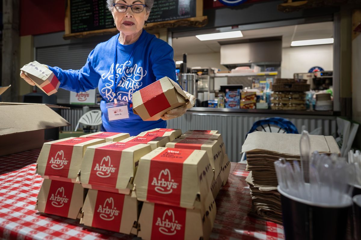 Millie Hynes stacks donated Arby’s sandwiches, getting dinner ready for the night-shift volunteers at the 2024 Christmas Bureau. This year, the Arby’s restaurant at 10407 E. Sprague Ave. provided volunteers with lunch every day the Bureau was open.  (COLIN MULVANY/The Spokesman-Review)