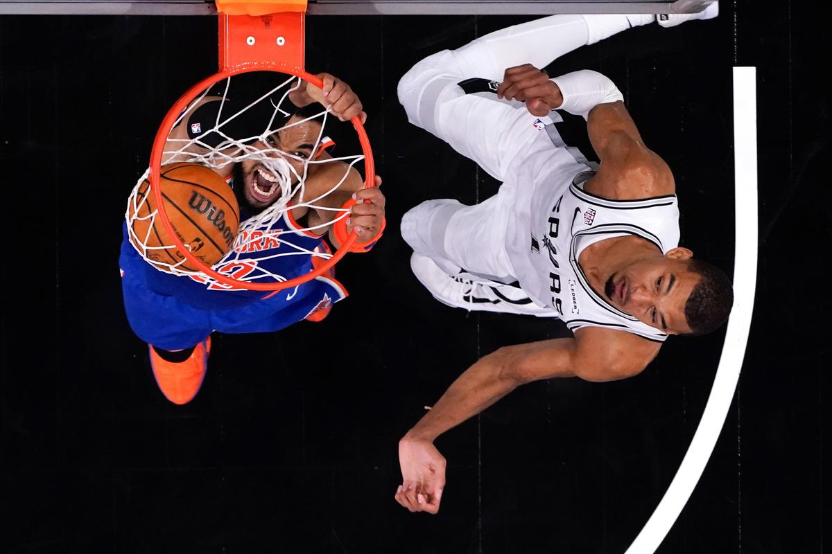Knicks forward Karl-Anthony Towns dunks the ball against Spurs center Victor Wembanyama during Game 2 of the NBA Finals on Friday at Frost Bank Center in San Antonio, Texas. (Getty Images)