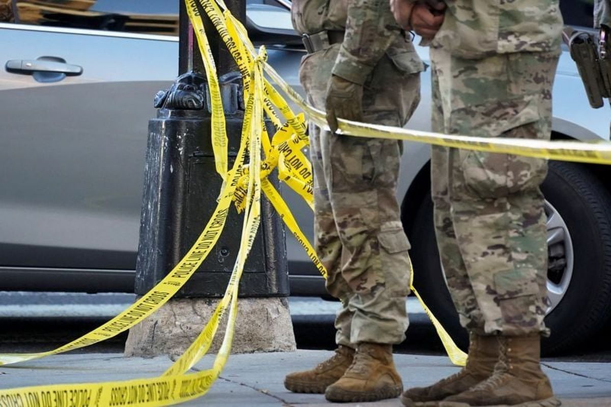 National Guard members stand together behind yellow tape Wednesday after two National Guard members were shot near the White House in Washington, D.C.  (Nathan Howard)