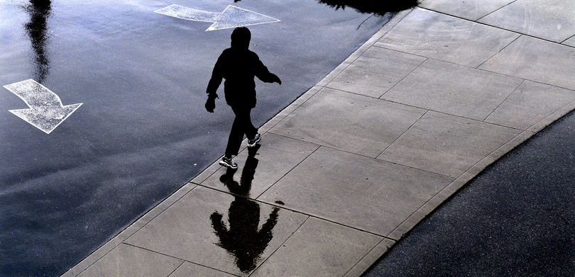 A woman walking near the Coeur d'Alene Resort on Wednesday wore a hooded jacket to protect herself from the rain/snow mix that blanketed the region. (Kathy Plonka / The Spokesman-Review)