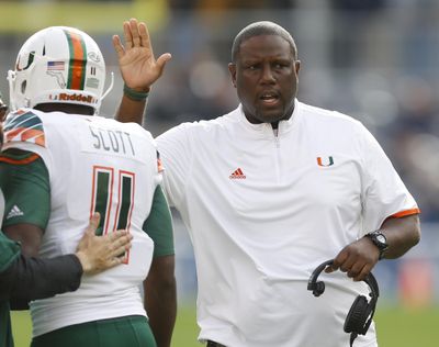 Miami head coach Larry Scott gets Miami wide receiver Rashawn Scott after the team scored a touchdown in the first quarter of an NCAA college football game against Pittsburgh. Scott is the interim coach at Miami and will lead the Hurricanes into the Sun Bowl against Washington State on Dec. 26. (Keith Srakocic / Associated Press)