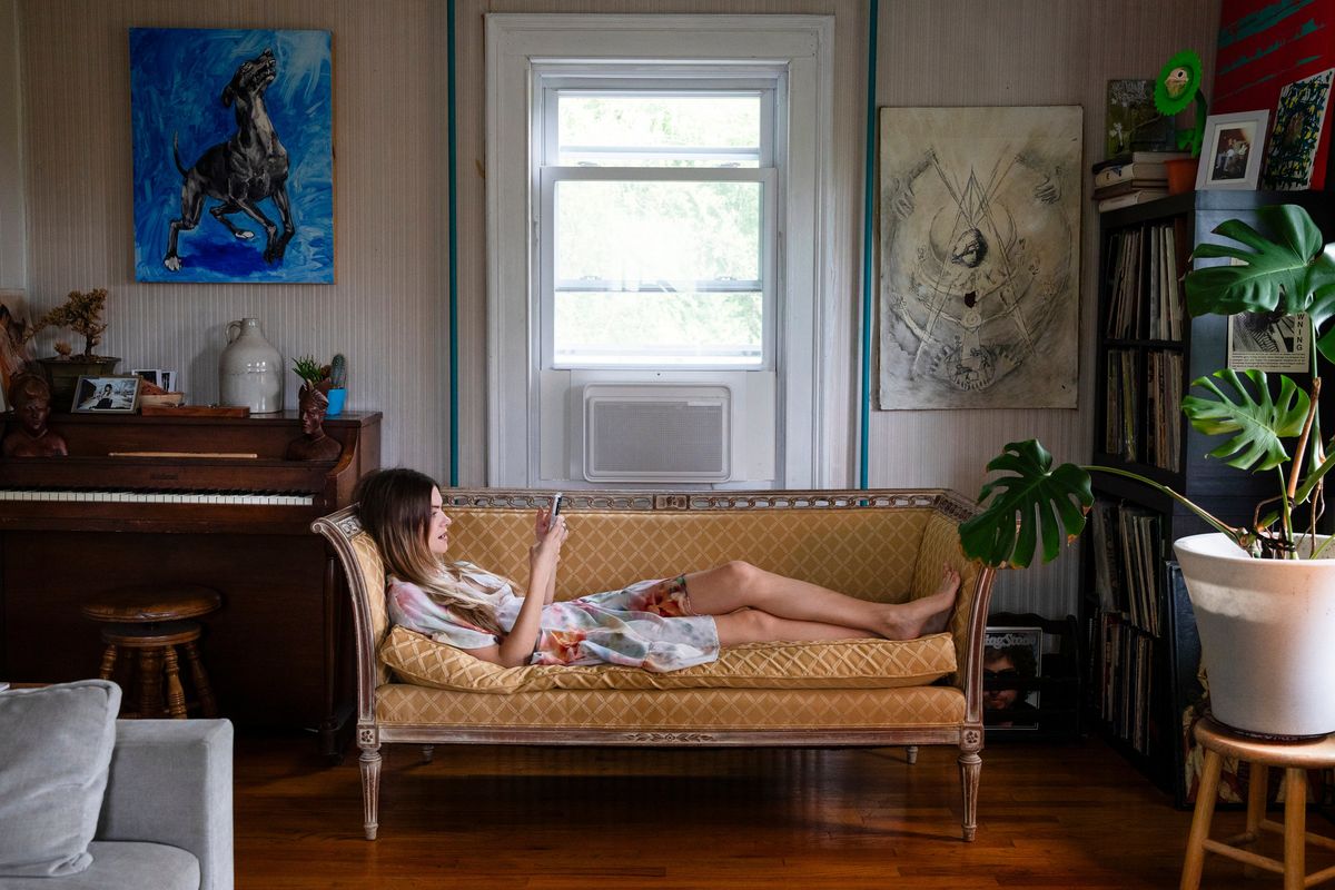 Jess Brush, 31, a nail artist, sits near one of the two Windmill units she ordered for her Hudson Valley farmhouse after seeing them on social media, in Marlboro, N.Y., on June 19.  (New York Times)