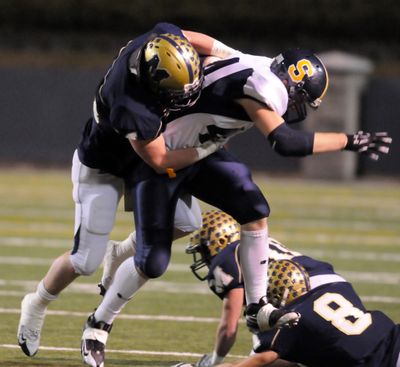 Mead’s Bryce Peters, left, rides down Southridge’s Austin Graves in the first quarter.  (Jesse Tinsley / The Spokesman-Review)