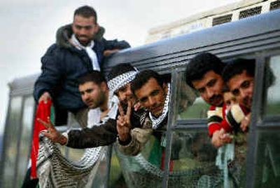 
Freed prisoners wave as they are taken by bus to the West Bank town of Jenin on Monday. 
 (Associated Press / The Spokesman-Review)