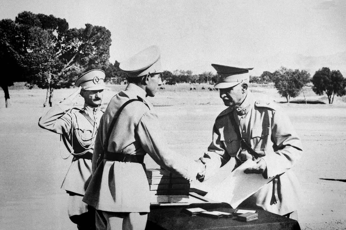 FILE- In this August 19, 1941 file photo, Reza Shah Pahlavi, hands second son, Ali Reza, commission as officer at graduation exercises at Iran’s “West Point” in Tehran, Iran prior to Anglo-Russian action. The discovery in Iran of a mummified body near the site of a former royal mausoleum has raised speculation it could be the remains of the late Reza Shah Pahlavi, founder of the Pahlavi dynasty. (AP)