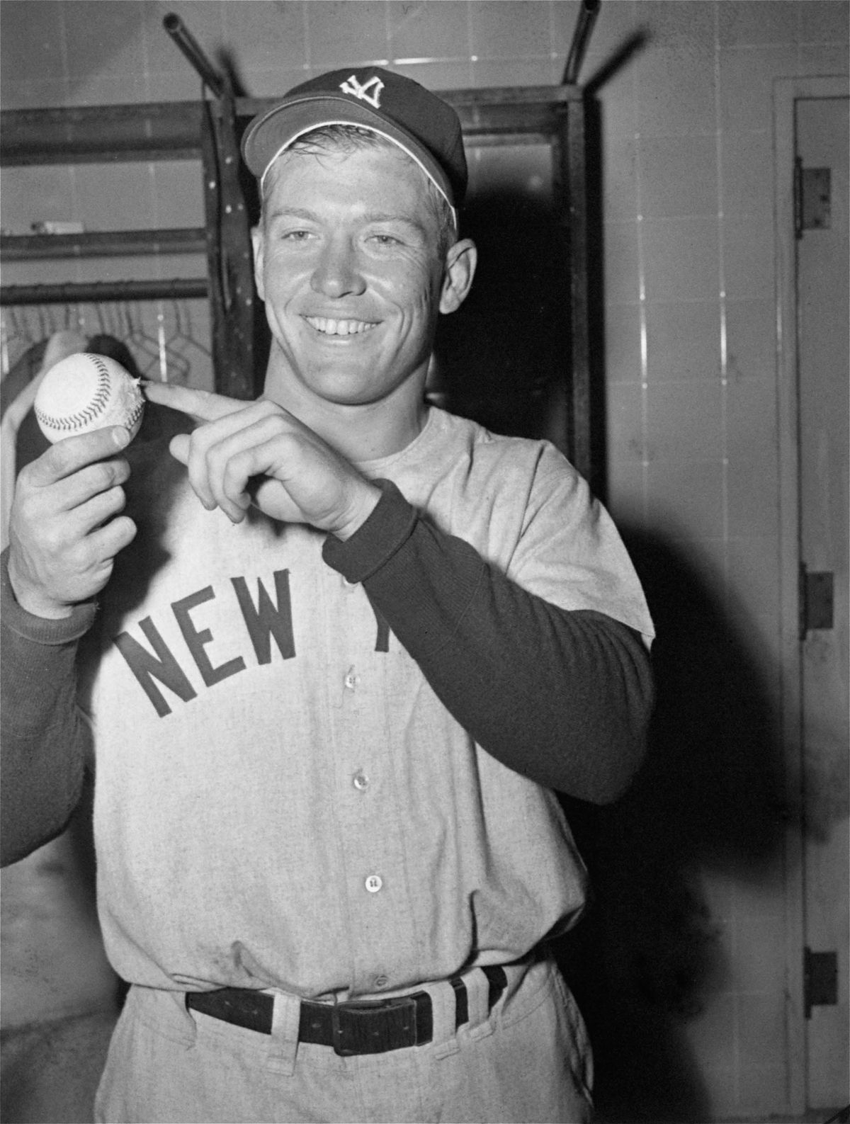 Mickey Mantle of the New York Yankees holds the ball he hit for 565 feet April 17, 1953, the longest homer ever hit in Griffith Stadium in Washington. Mantle, in the dressing room after the game with the Washington Senators, points to the dent in the ball where it hit a house after clearing center field. Residents of the house returned the ball to Mickey. The Yankees won 7-3.  (Associated Press)