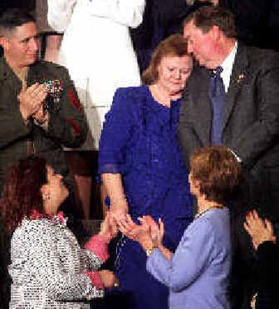
Janet and William Norwood hug after being acknowledged by President Bush during his speech. Applauding, from left are, Marine Staff Sgt. John Manuel Martinez, Safia Taleb al-Suhail, leader of the Iraqi Women's Political Council, and first lady Laura Bush. 
 (Associated Press photos / The Spokesman-Review)